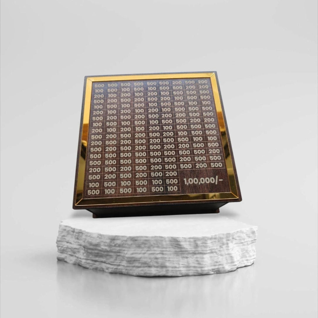 Display of gold coins with a value chart on a marble base against a white background