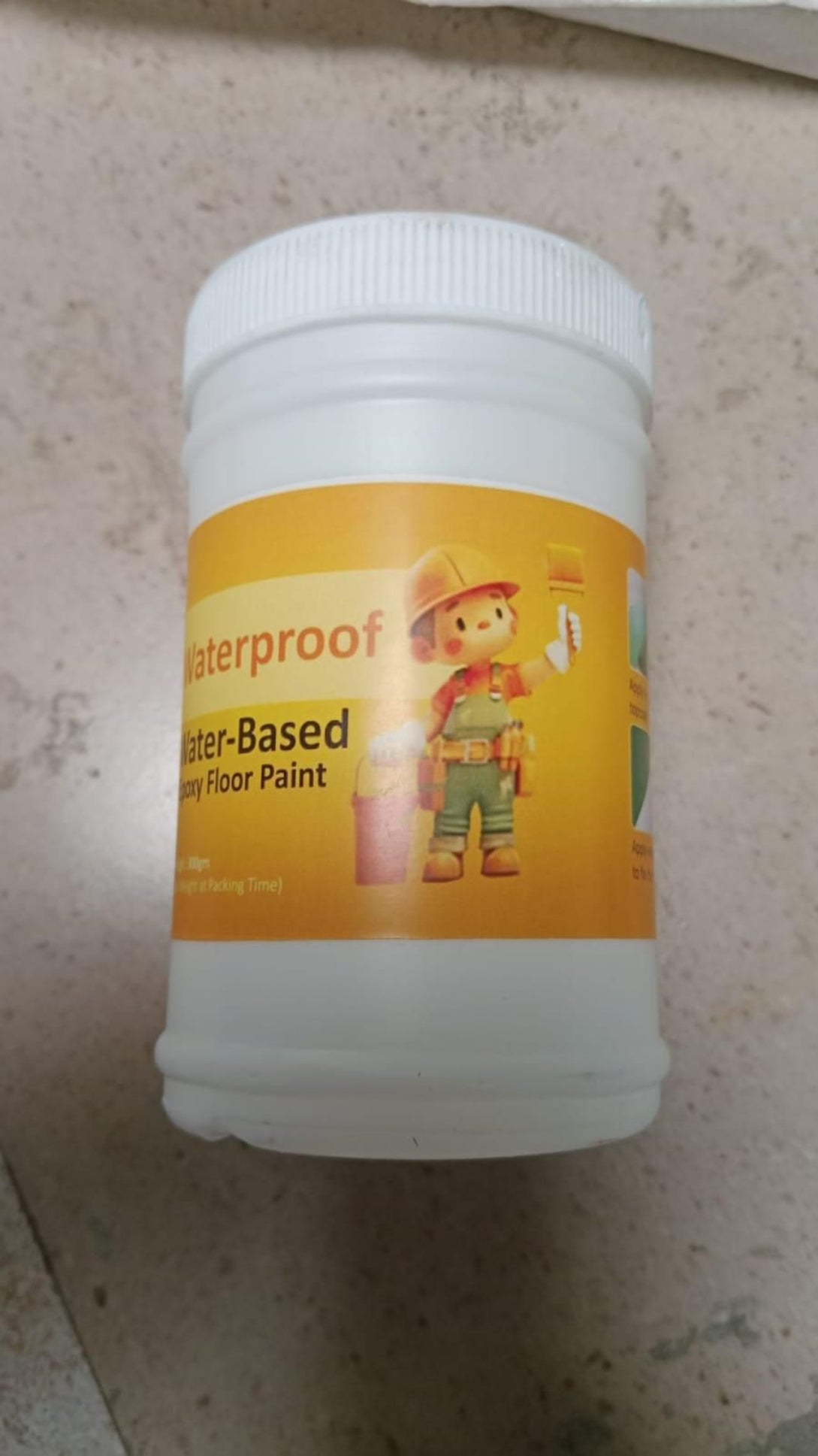 Container of waterproof floor paint with a child-like illustration on a textured surface
