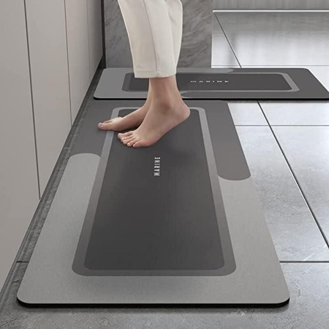Person standing on a gray mat with 'KINEN' branding in a bathroom setting.
