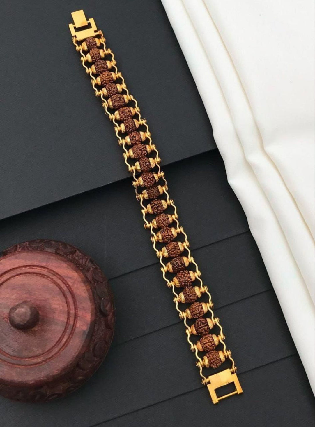 Gold bracelet with brown beads on a dark surface