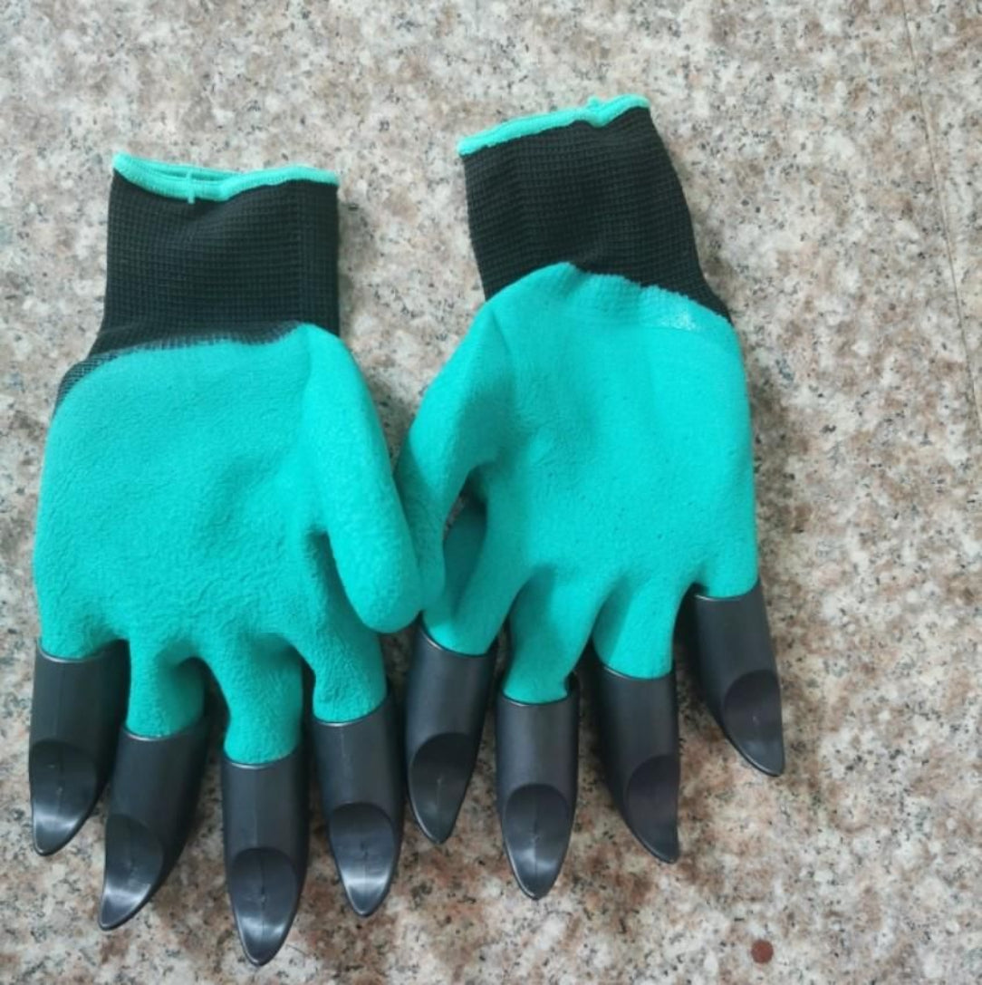 Pair of green gardening gloves with black gloves on a textured surface