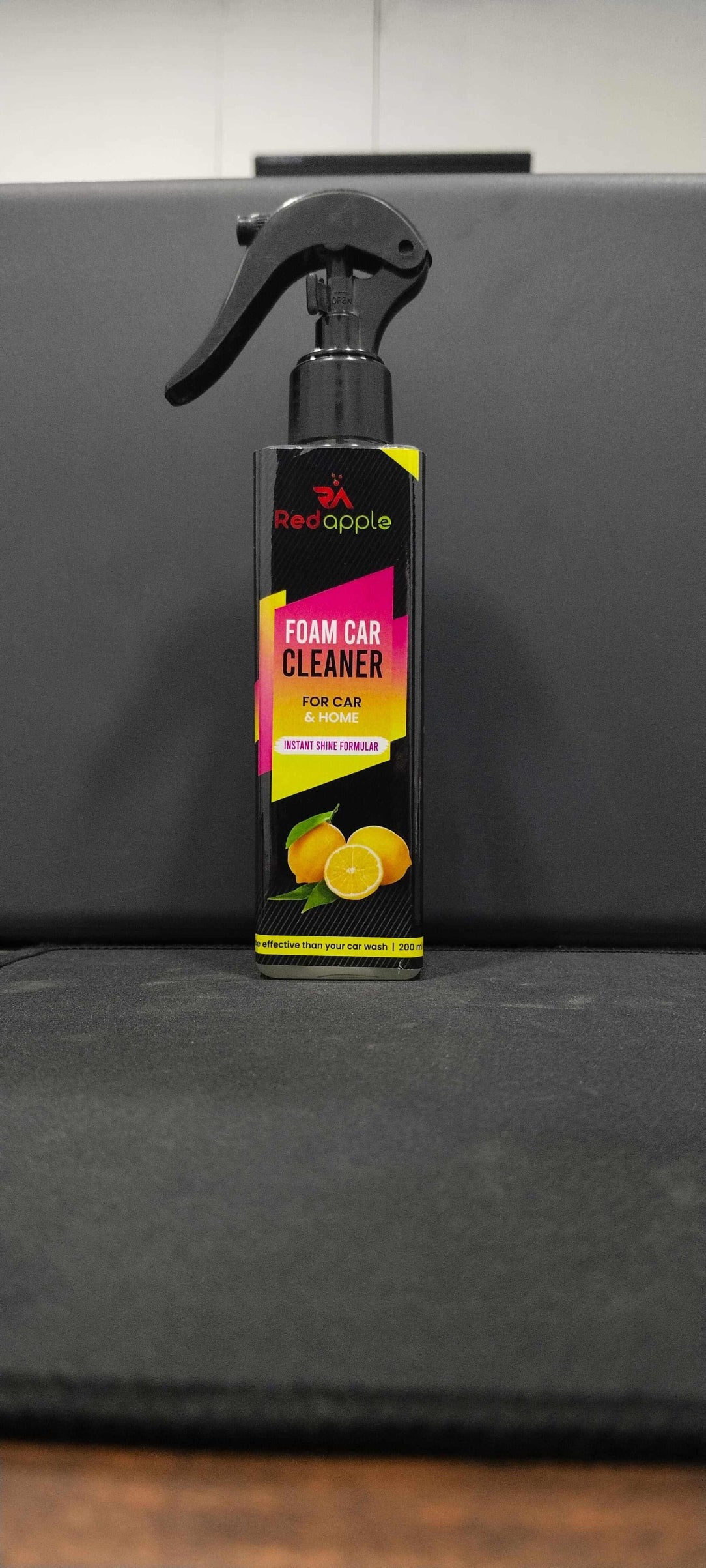 Foam car cleaner spray bottle with colorful label against a gray background.