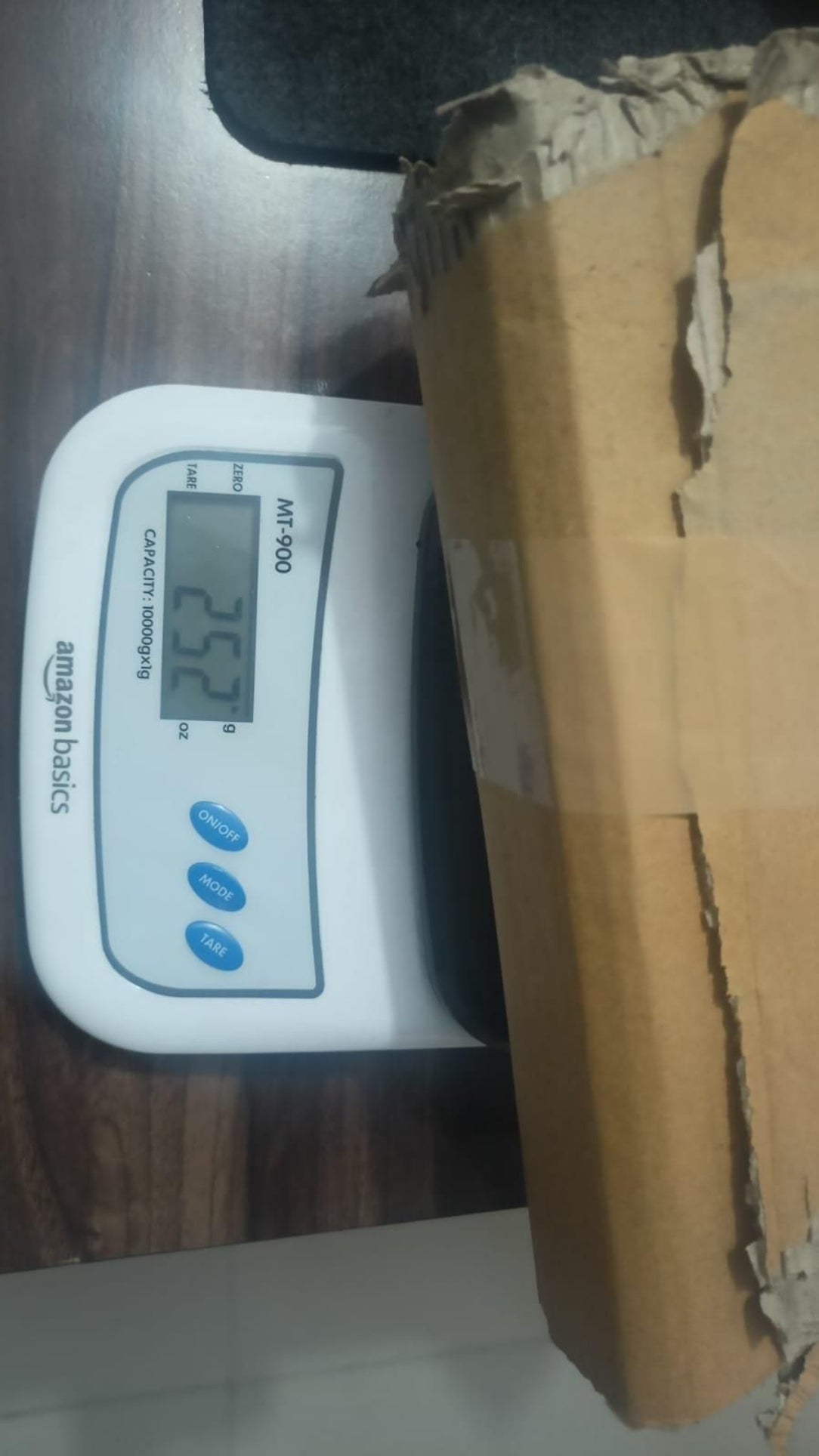 Digital scale displaying weight next to a cardboard box