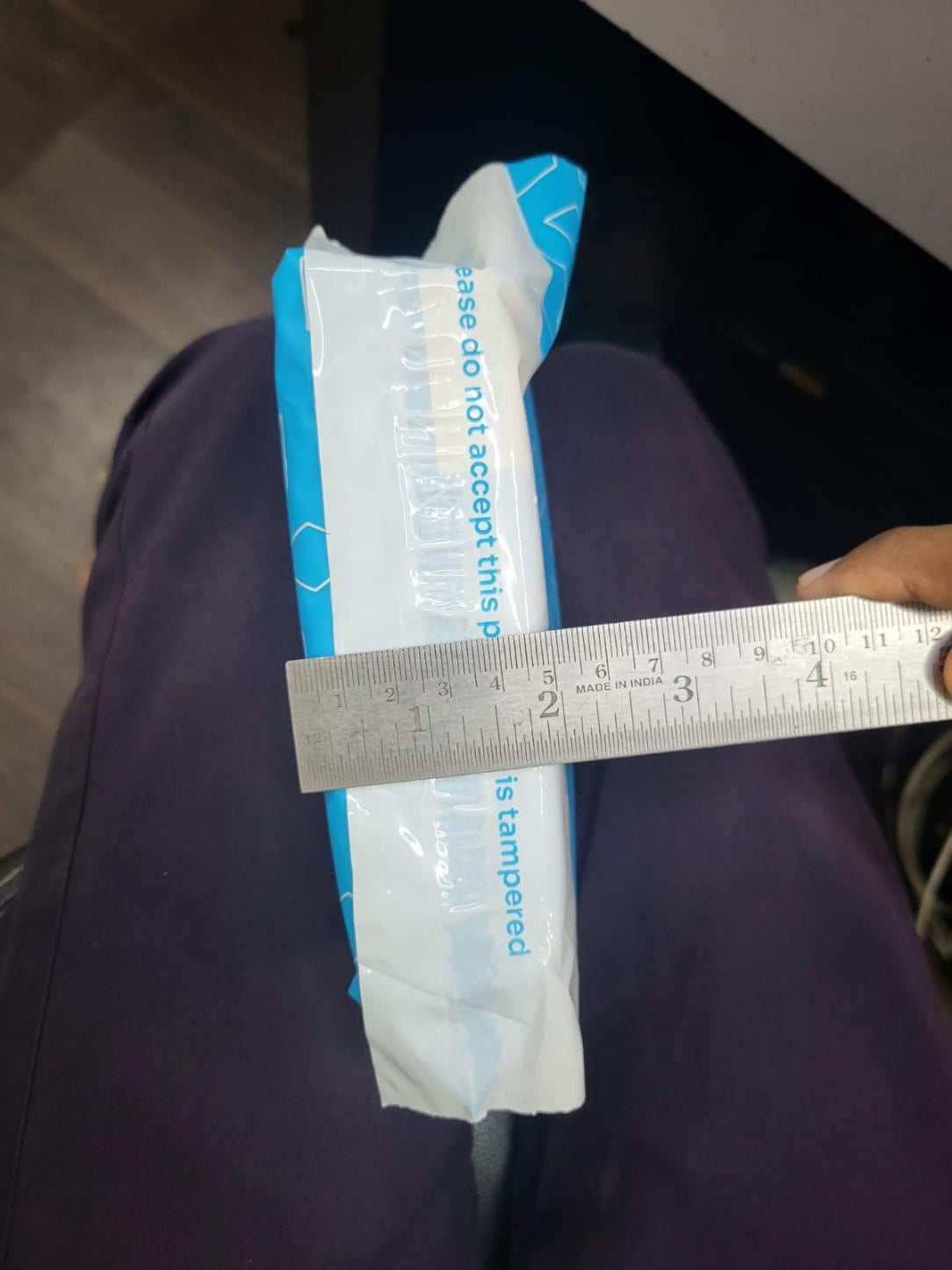 Rectangular product with a ruler for scale on a dark surface