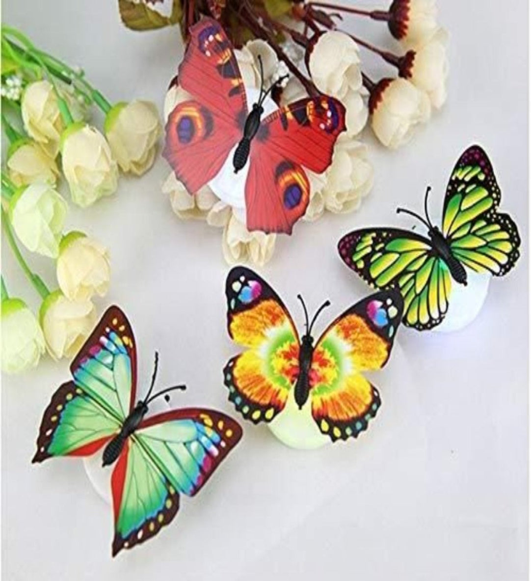 Colorful butterfly magnets on a white background with flowers.