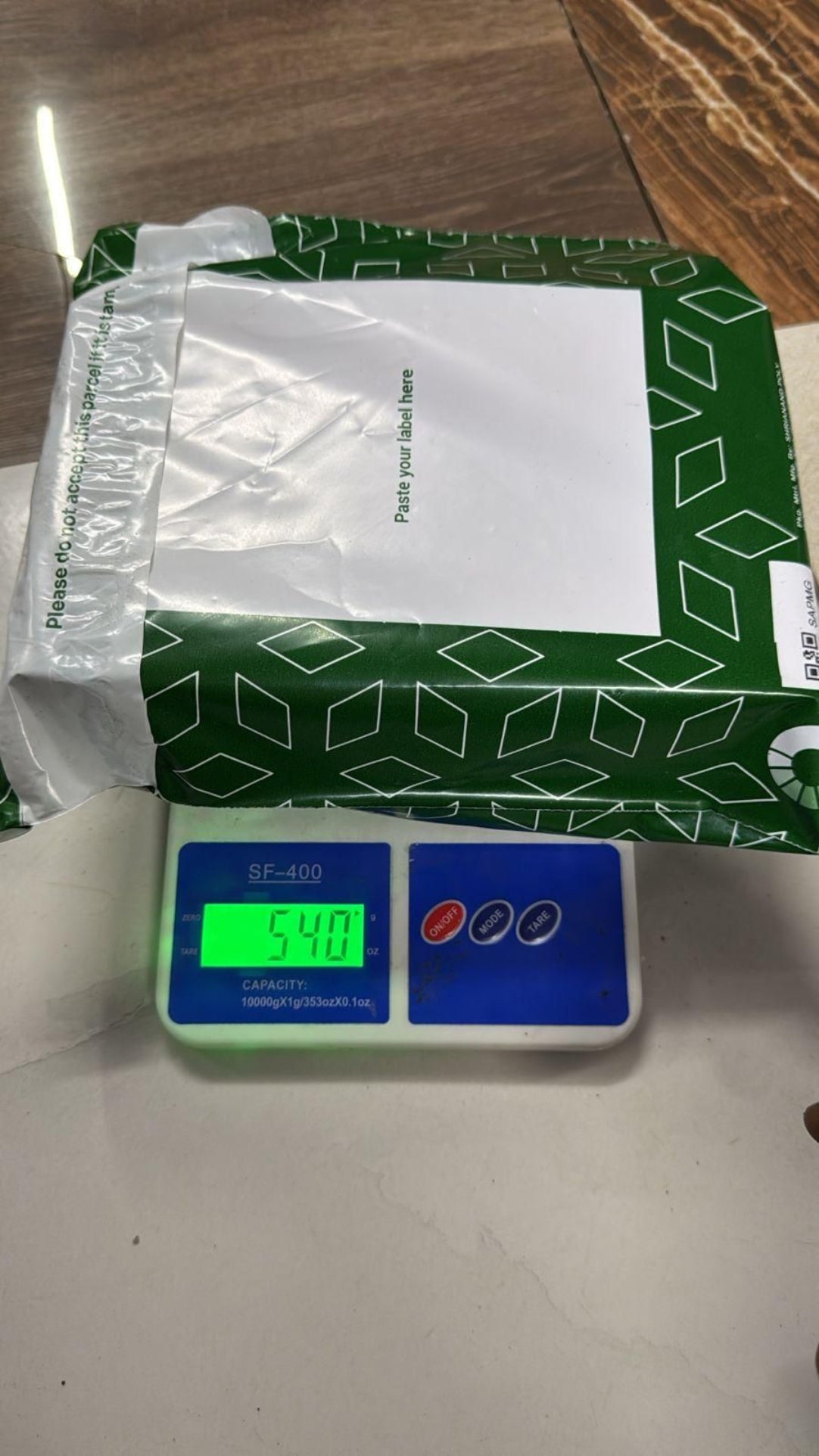 Green box with a white label on a digital scale displaying weight