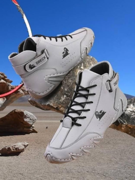 A pair of Men's Stylish Casual Shoes in gray color with laces, placed against a backdrop of a rocky landscape.