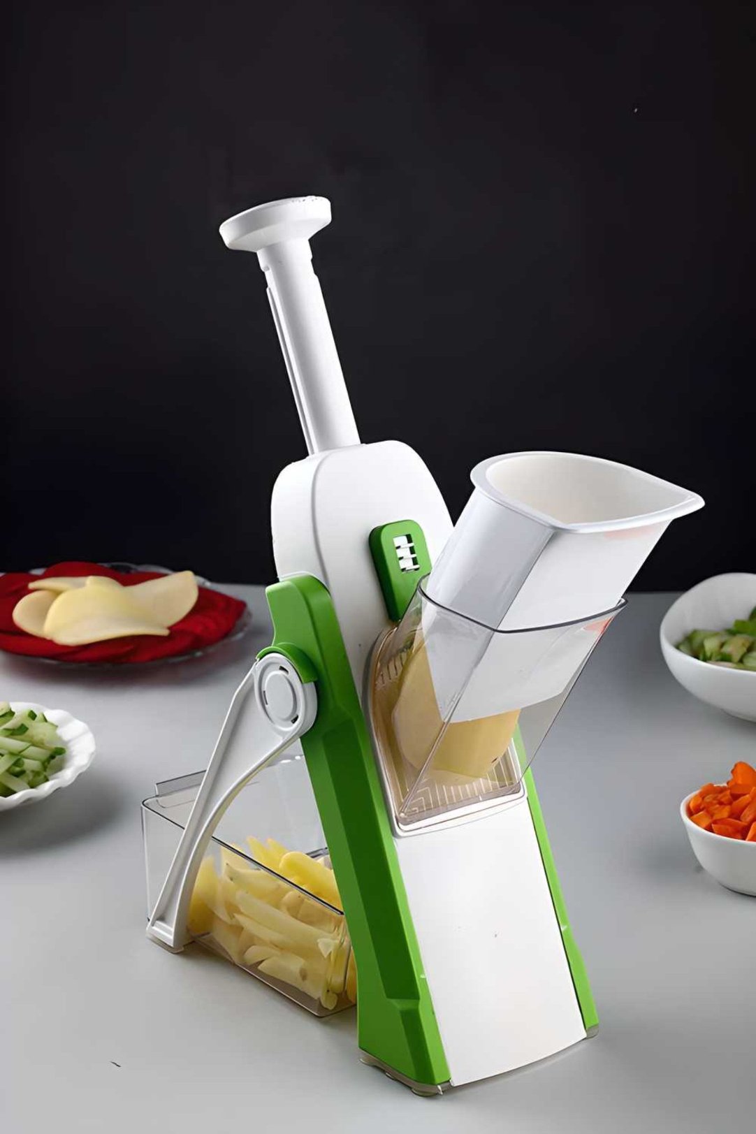 A green and white YouBee mandoline slicer with adjustable knobs, shown with sliced potatoes and other vegetables around it, indicating its use for slicing.