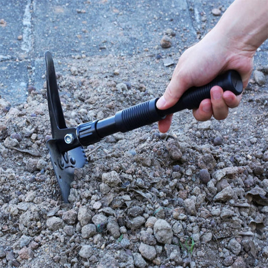 Person using a tool to dig through gravel on a concrete surface