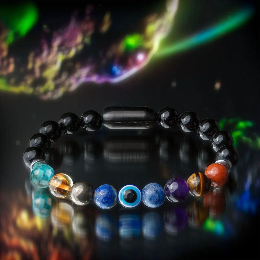Multicolored beaded bracelet on a reflective surface with a cosmic background