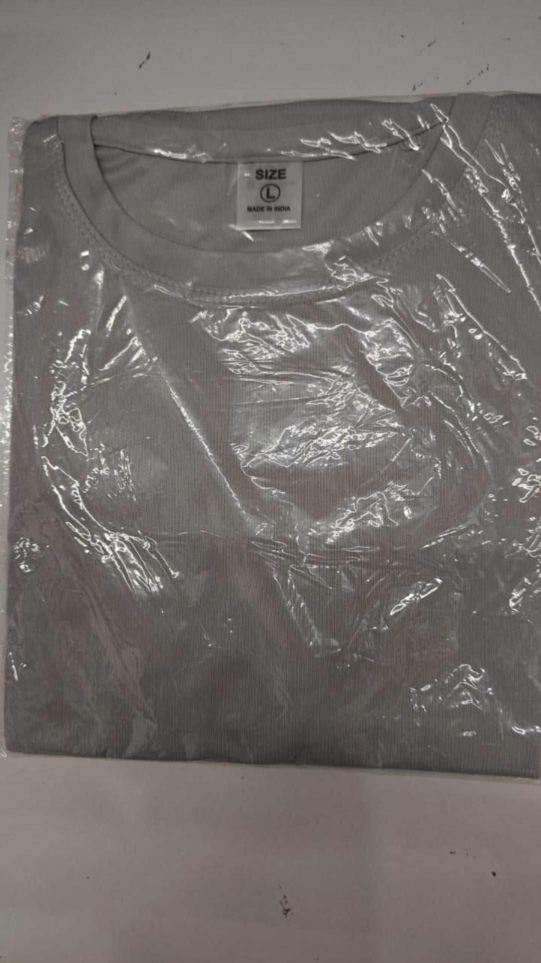 Gray t-shirt with a brand label on a white background