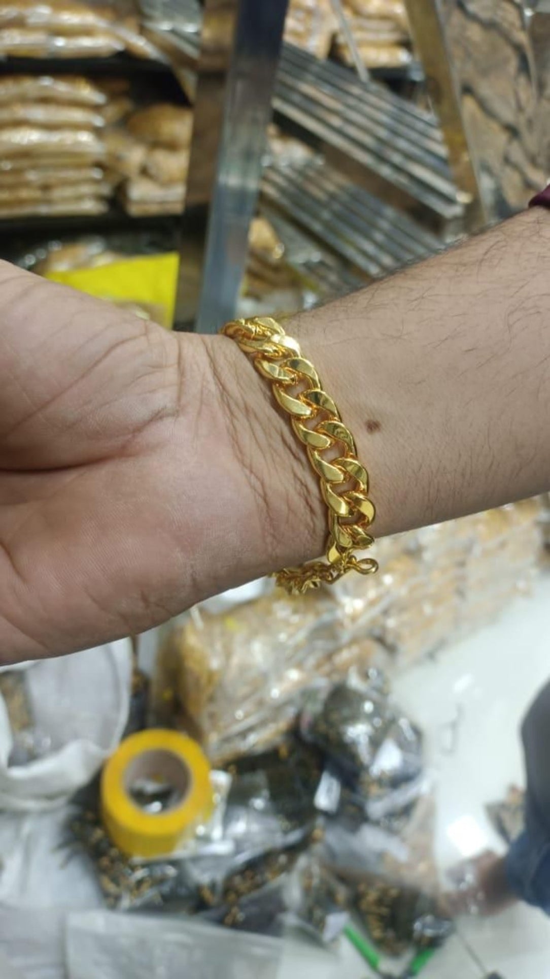 Gold chain bracelet on a wrist with a blurred background