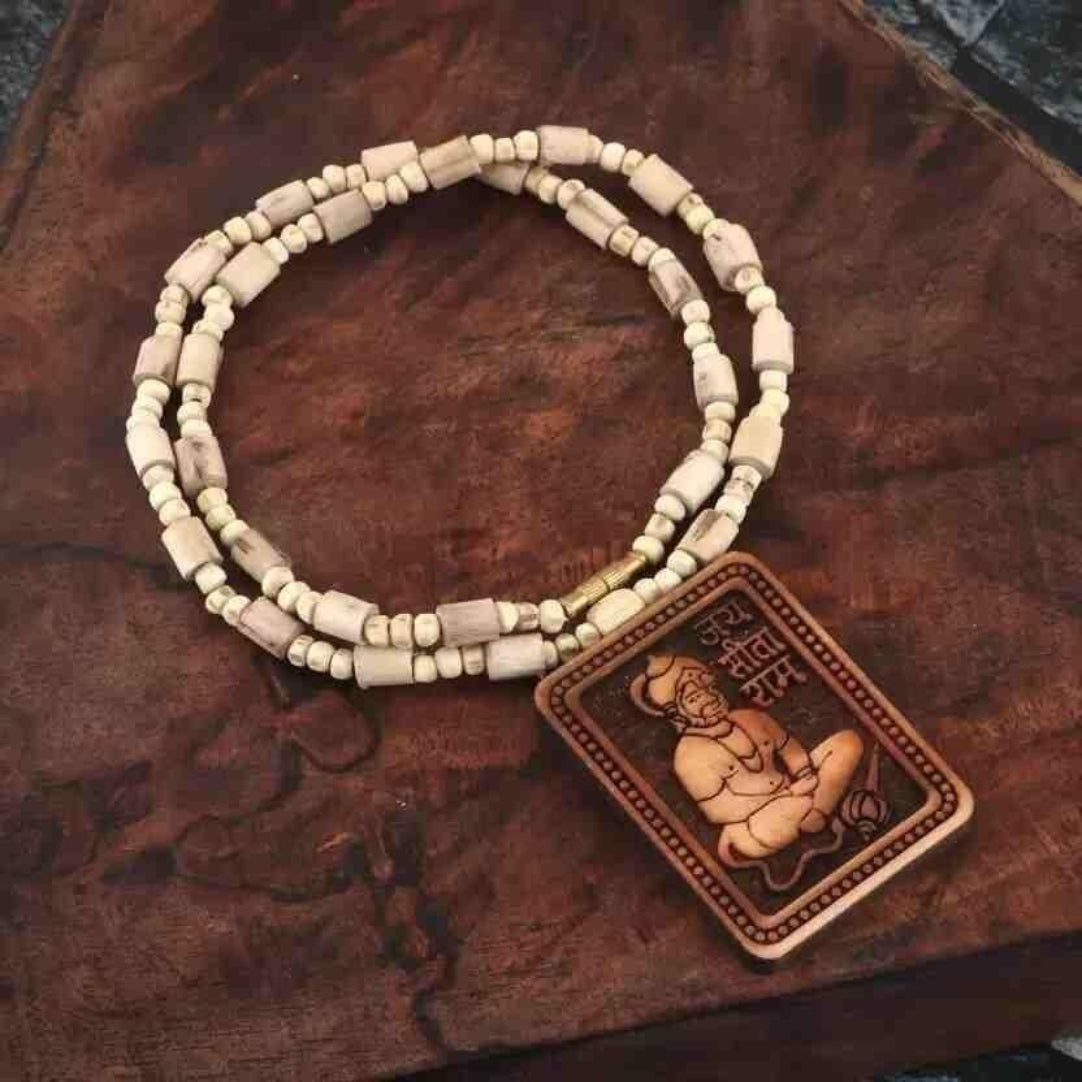 Beaded necklace with a Buddha pendant on a wooden surface