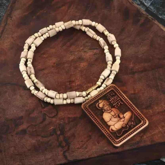 Beaded necklace with a Buddha pendant on a wooden surface