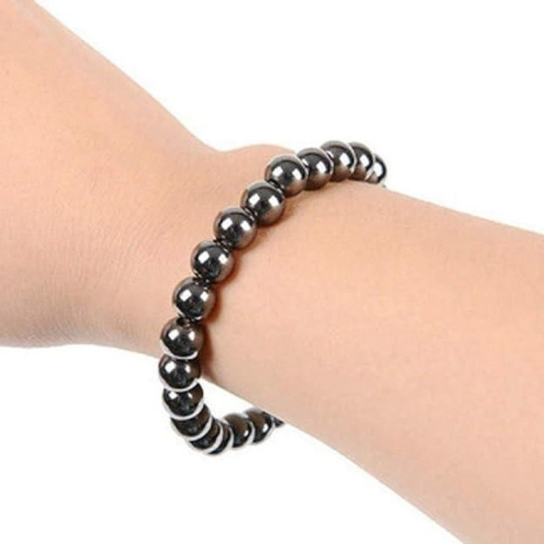 Black beaded bracelet on a wrist against a white background