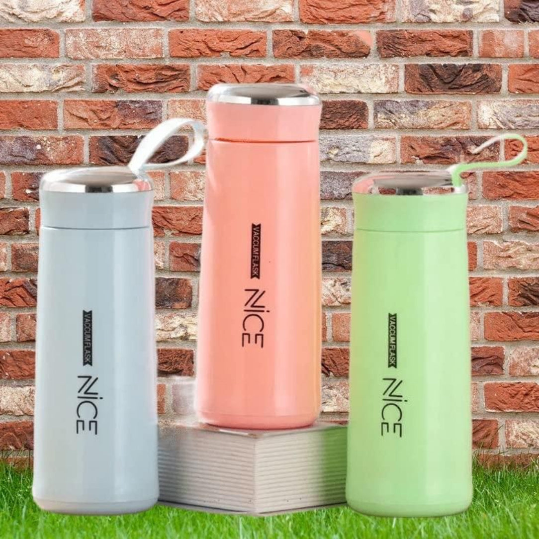 Three colorful thermos bottles with 'NICE' branding against a brick wall.