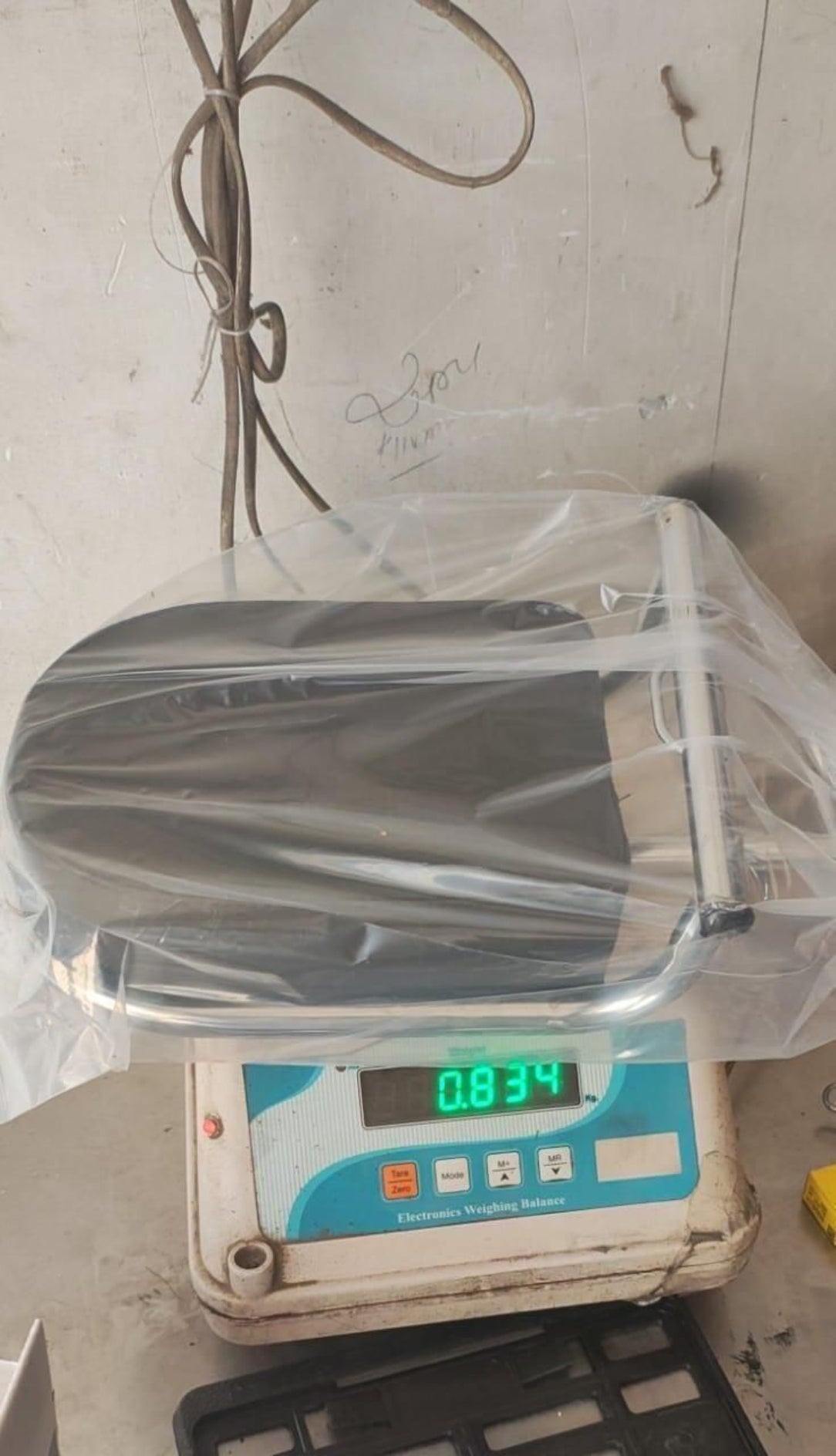 Digital scale with a transparent plastic cover on a white surface