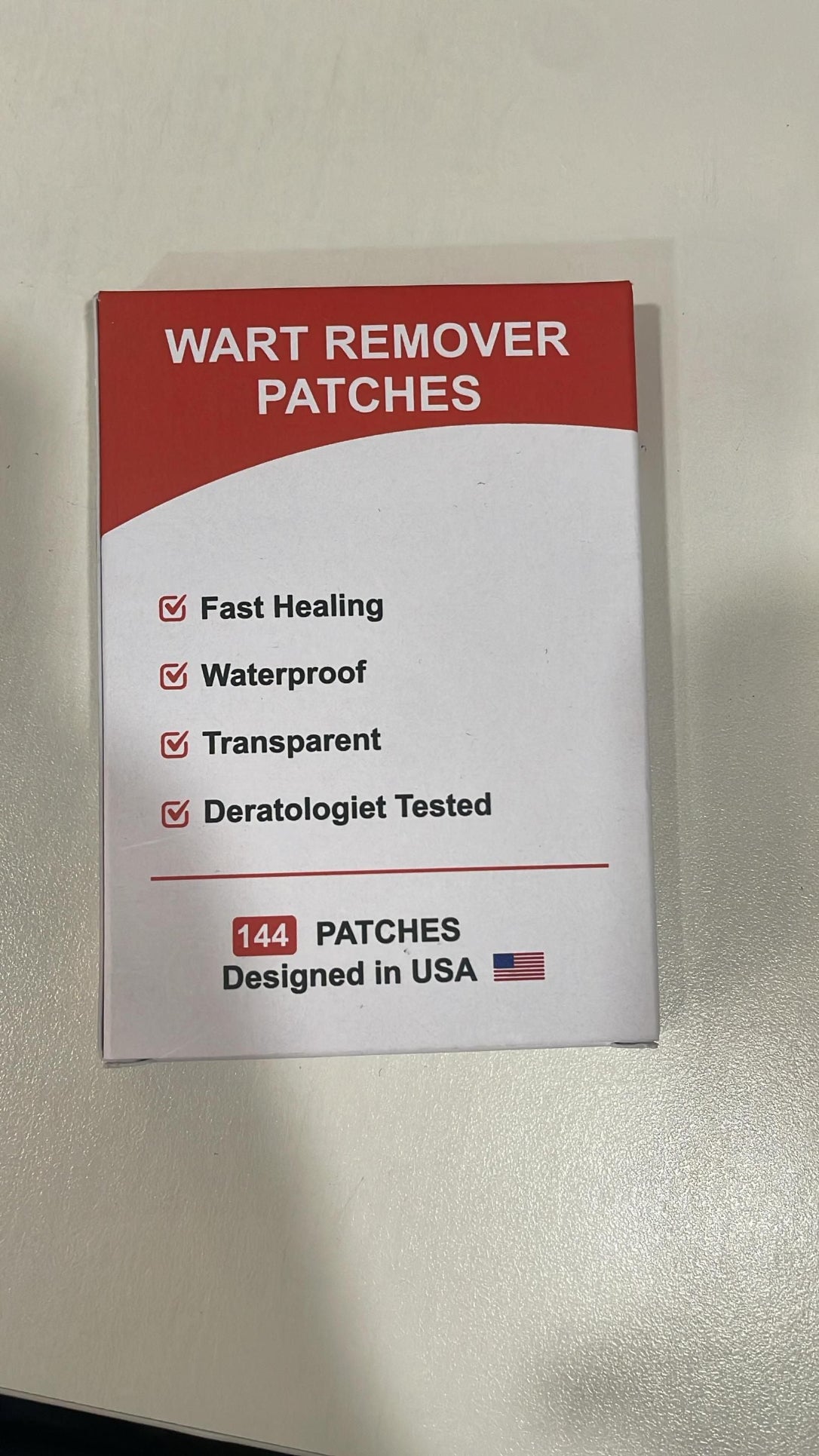 Wart remover patches packaging with red and white design on a beige background