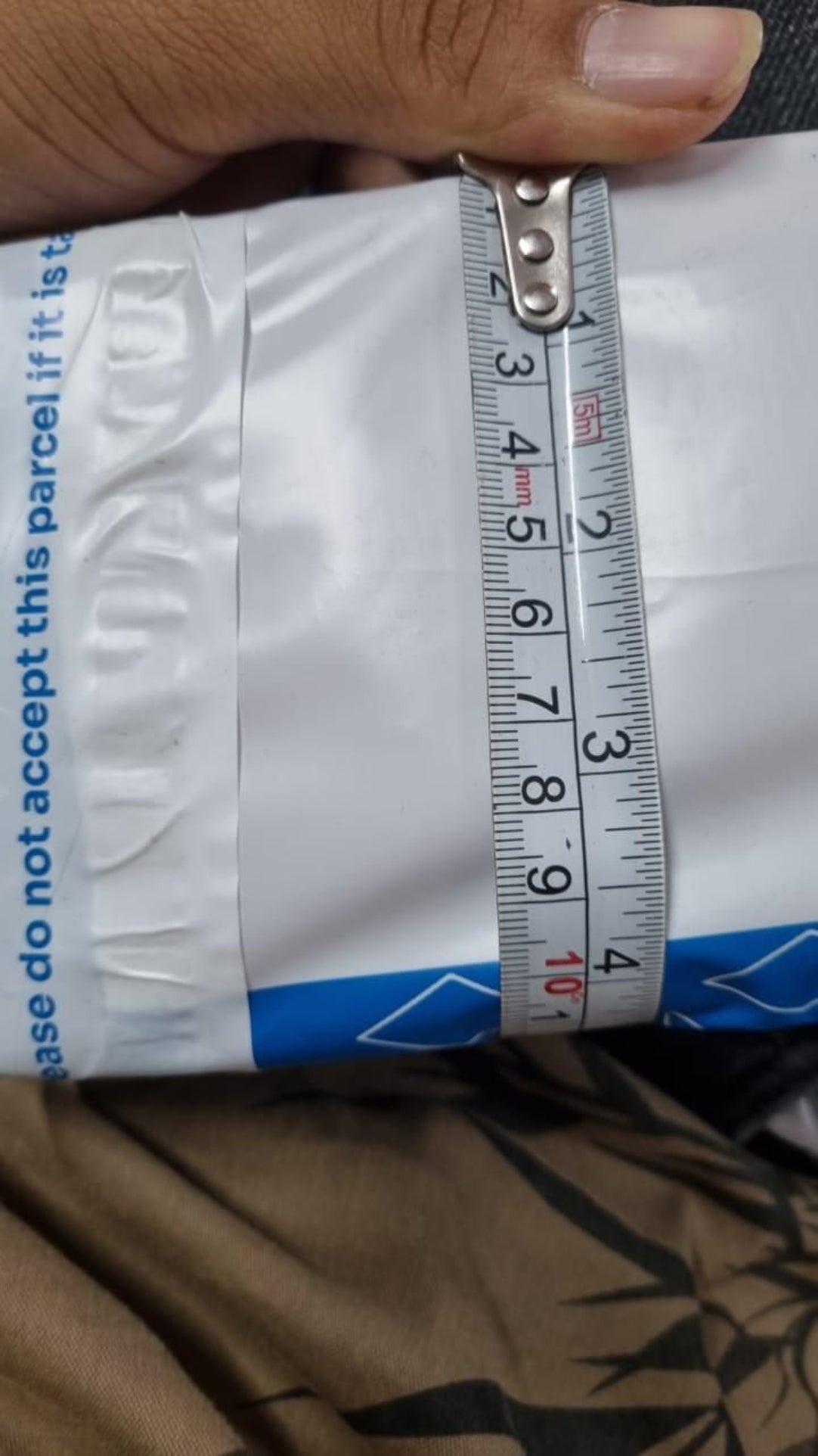 Package with a measuring tape on top, indicating measurement or packaging process.