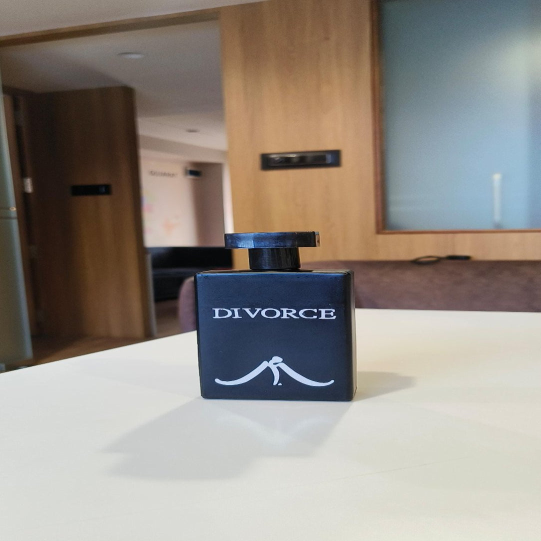 Perfume bottle with 'DIVORCE' packaging on a table in an indoor setting