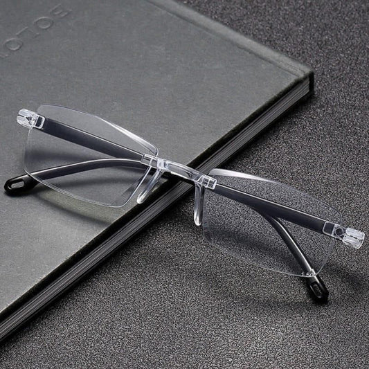 Clear rimless eyeglasses on a textured surface with a book in the background