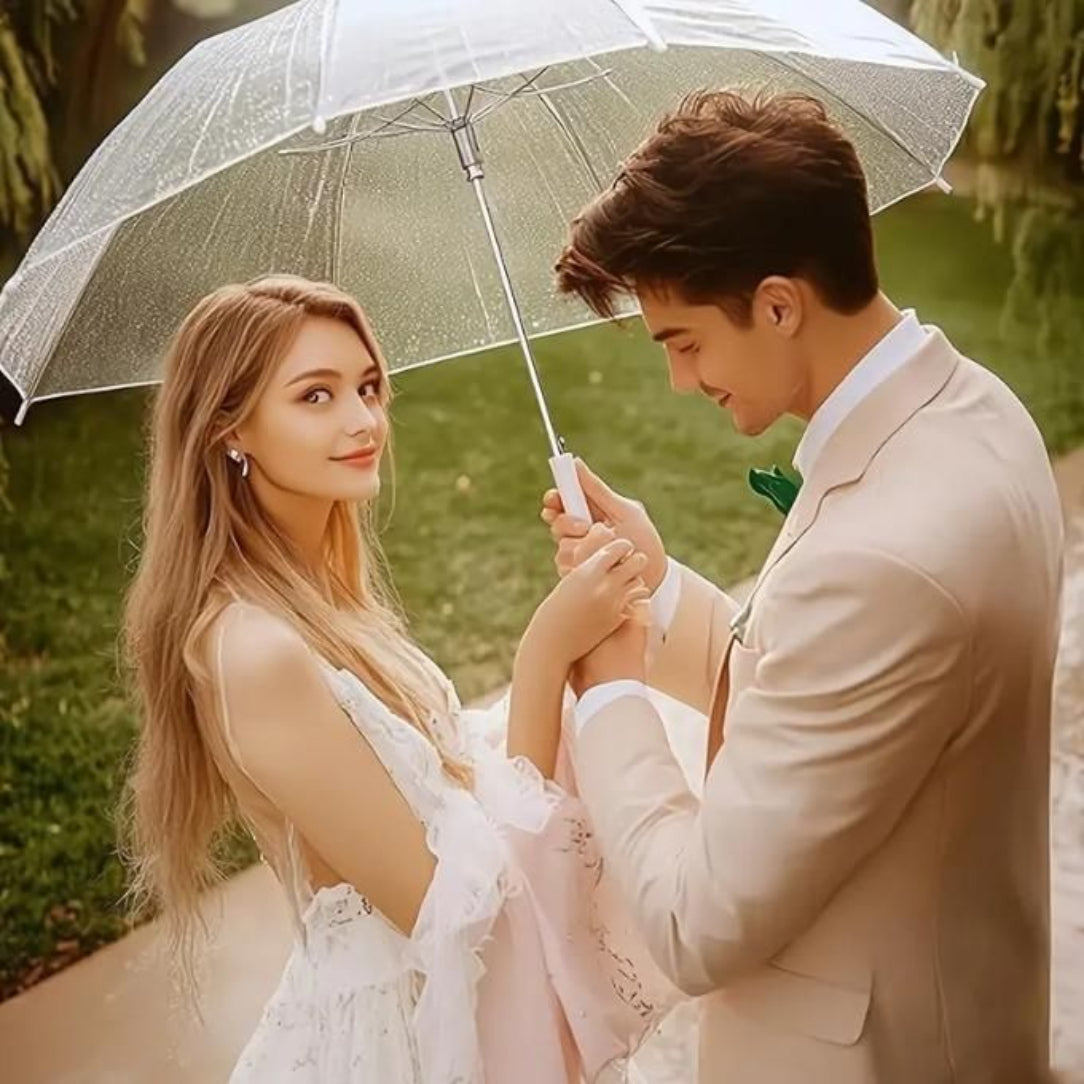 Couple holding hands under a transparent umbrella in a park setting