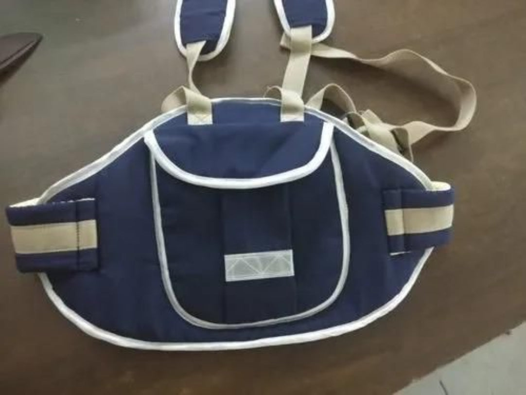 Navy blue baby carrier with straps on a brown surface