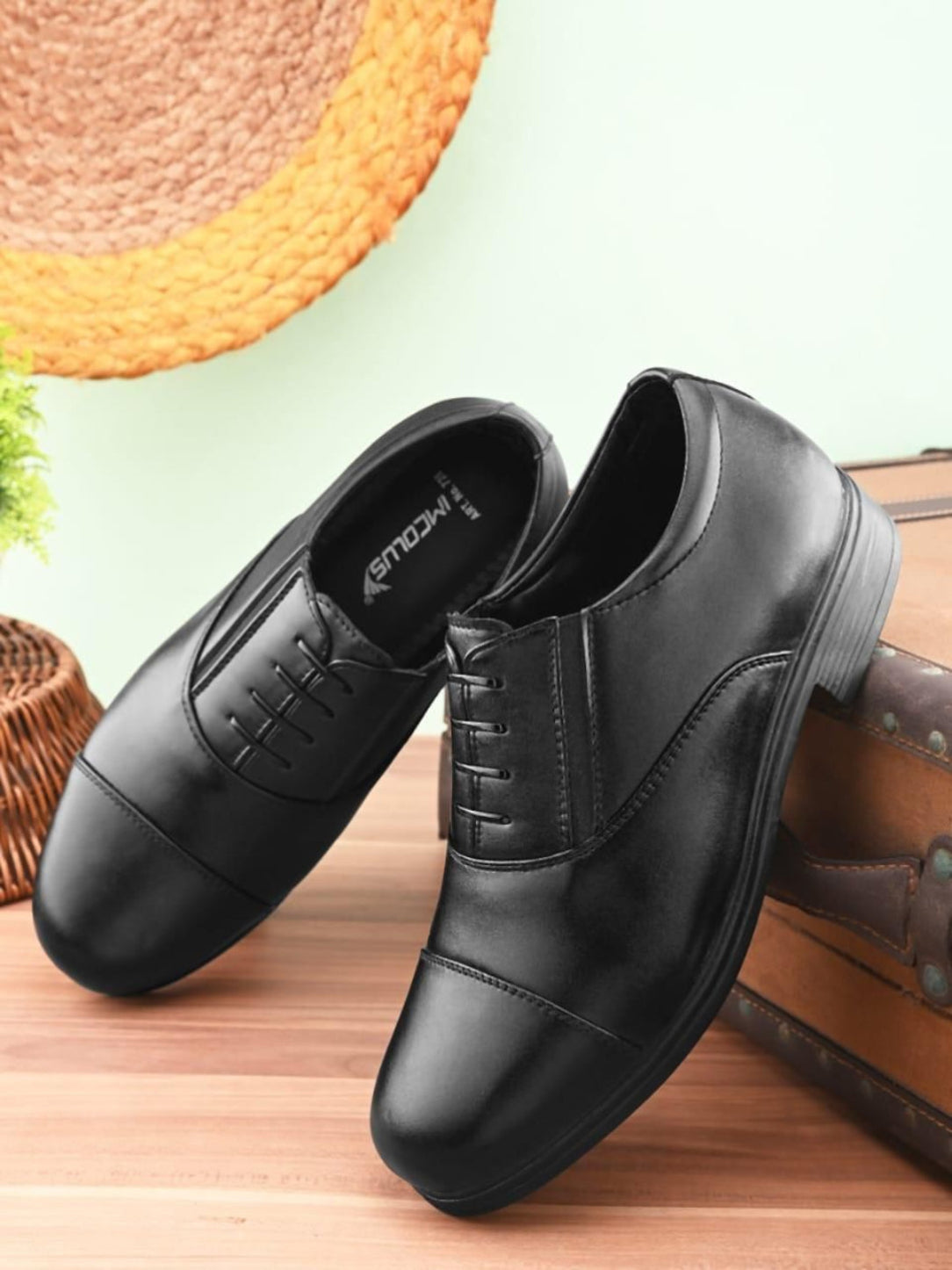 Black leather shoes on a wooden surface with a blurred background