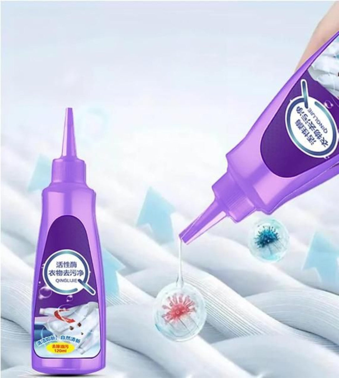 A bottle of purple fabric stain remover with a nozzle, shown spraying a liquid on a white fabric with a stain, with an inset image of the product label.