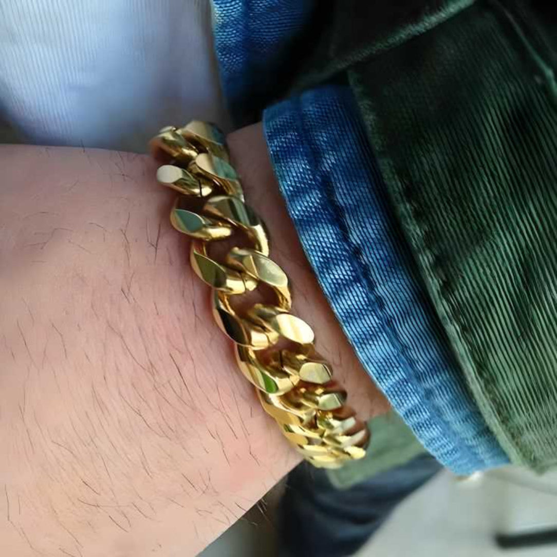 Gold chain bracelet on a wrist with a blurred background
