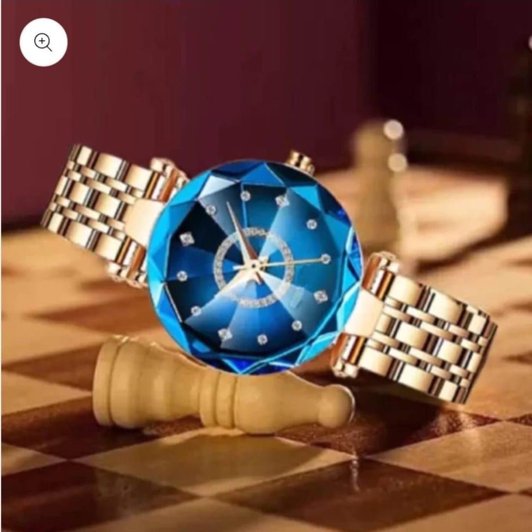 Gold watch with a blue gemstone face on a chessboard