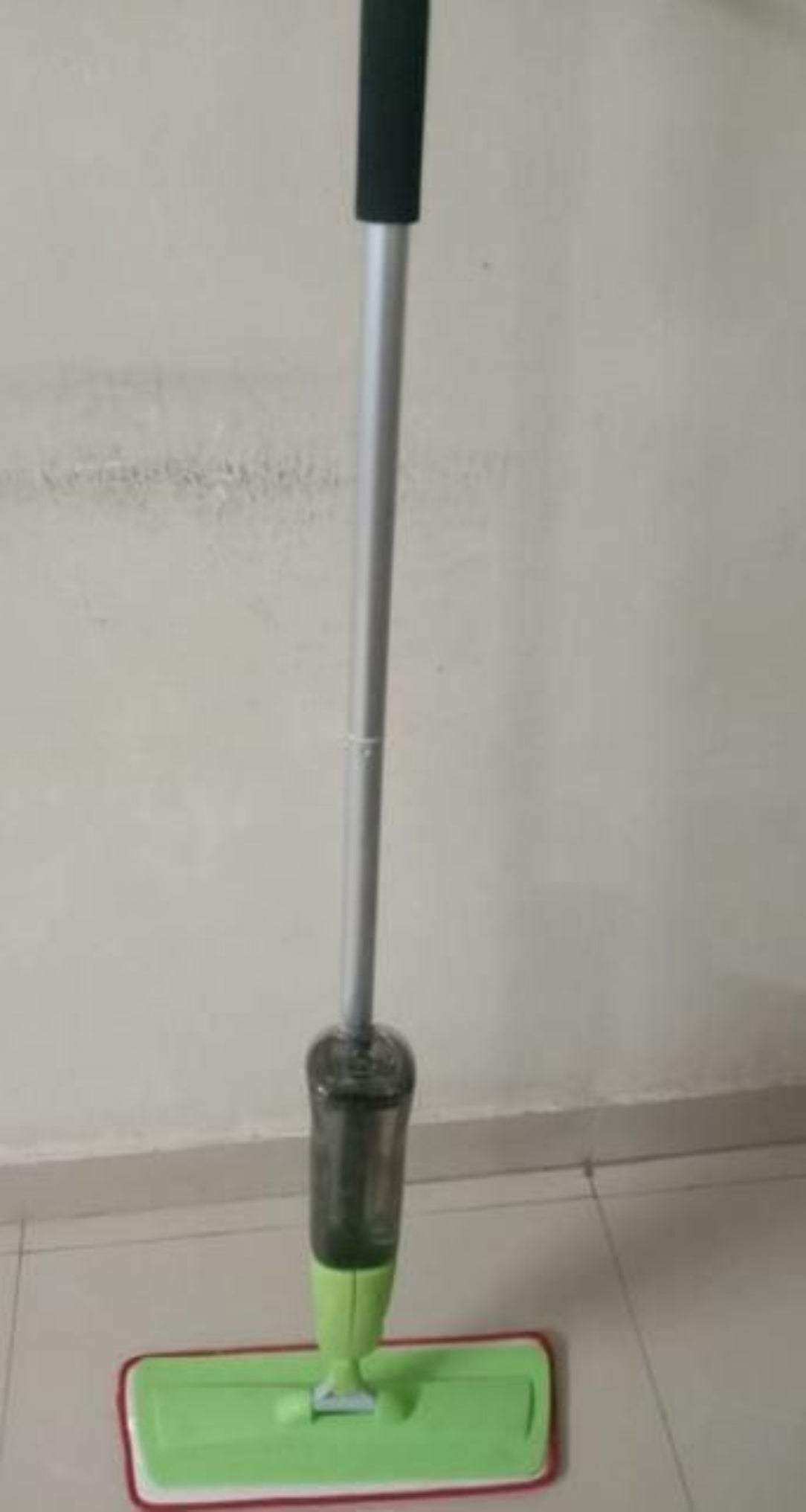 Cleaning tool with a long handle on a plain background