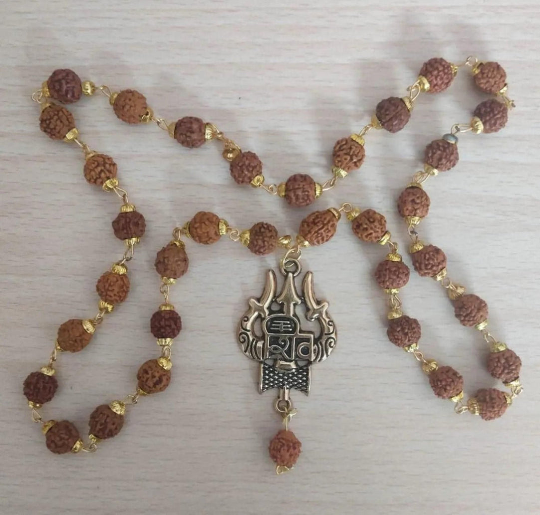 Necklace with brown beads and a silver pendant on a light wooden surface