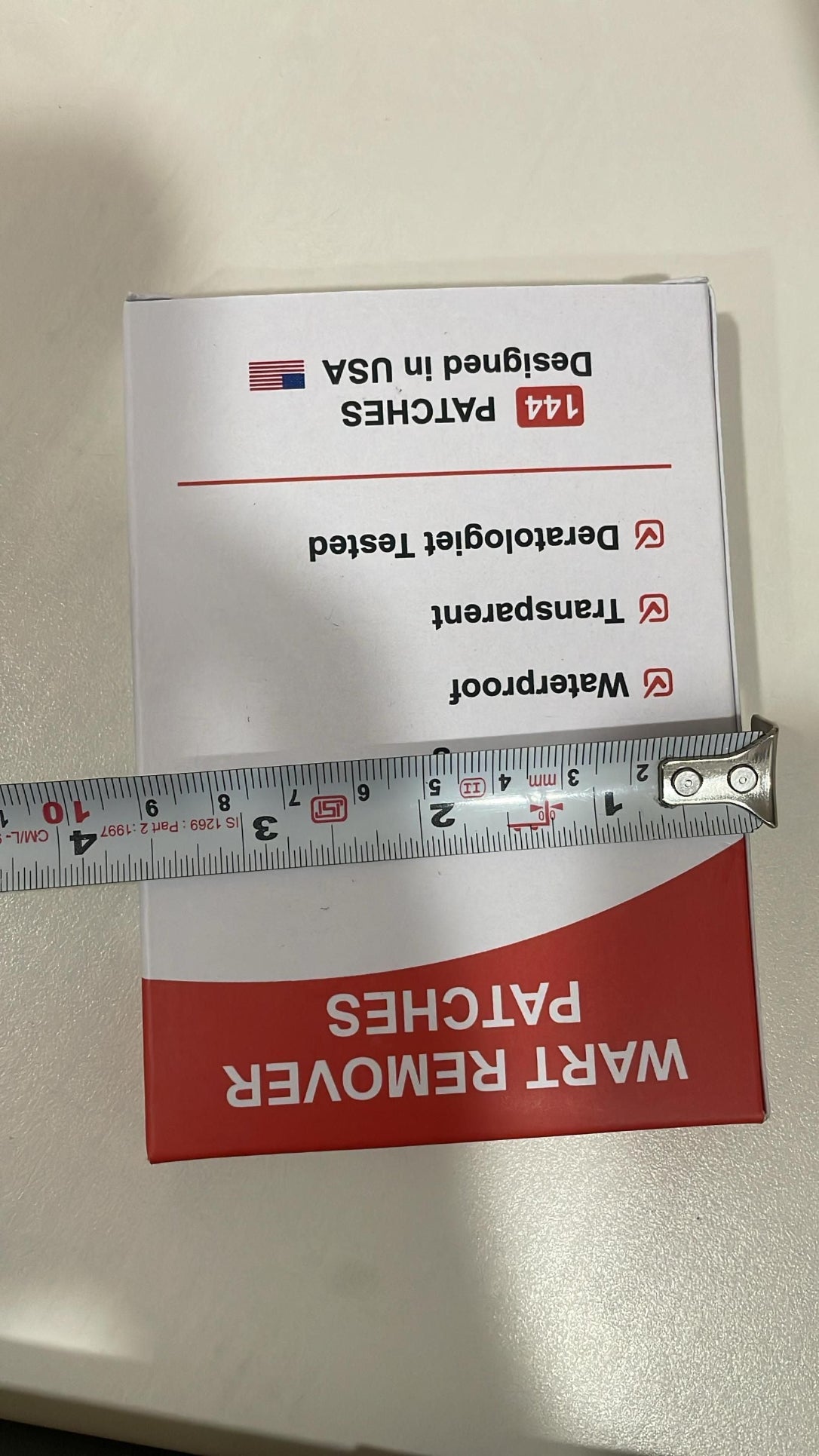 Box of Wart Remover Patches with a ruler for scale on a white surface