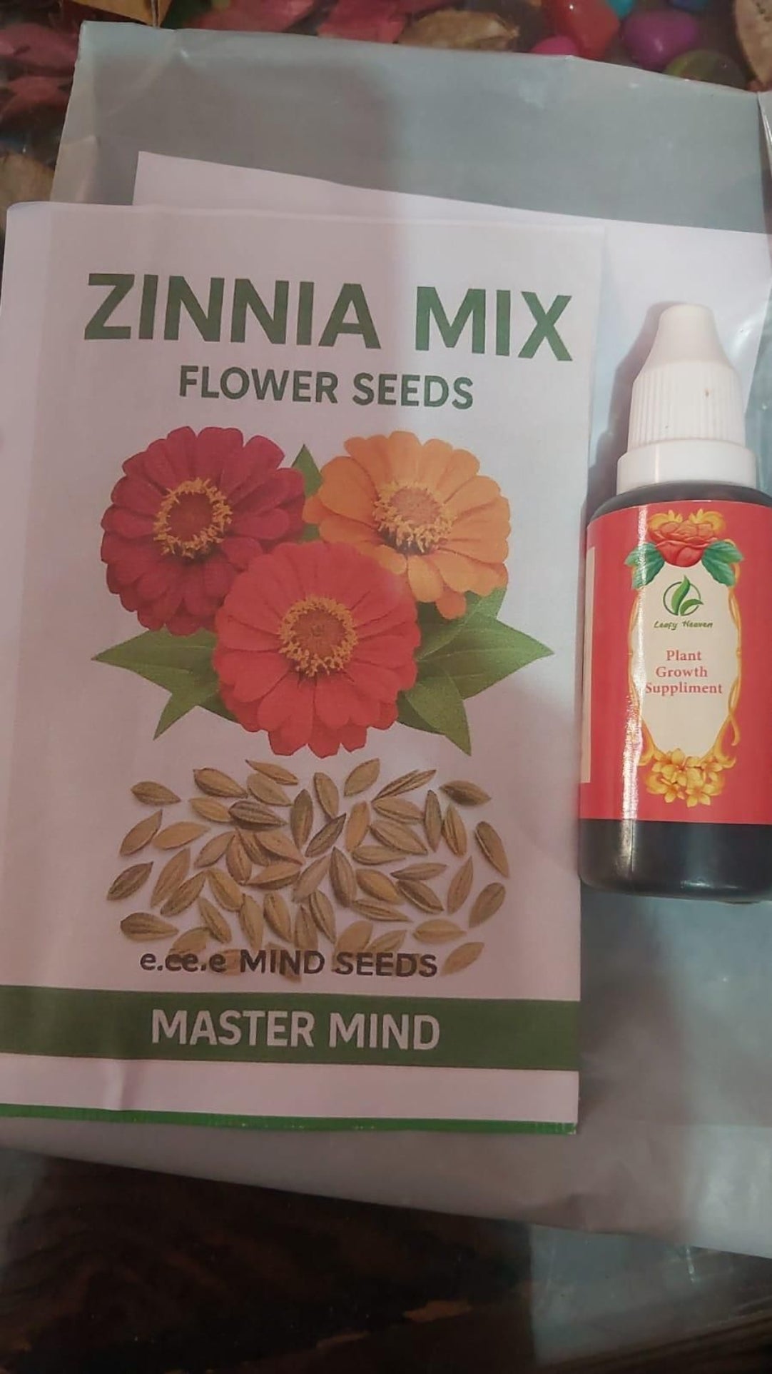 Zinnia mix flower seeds packet with a bottle on a table