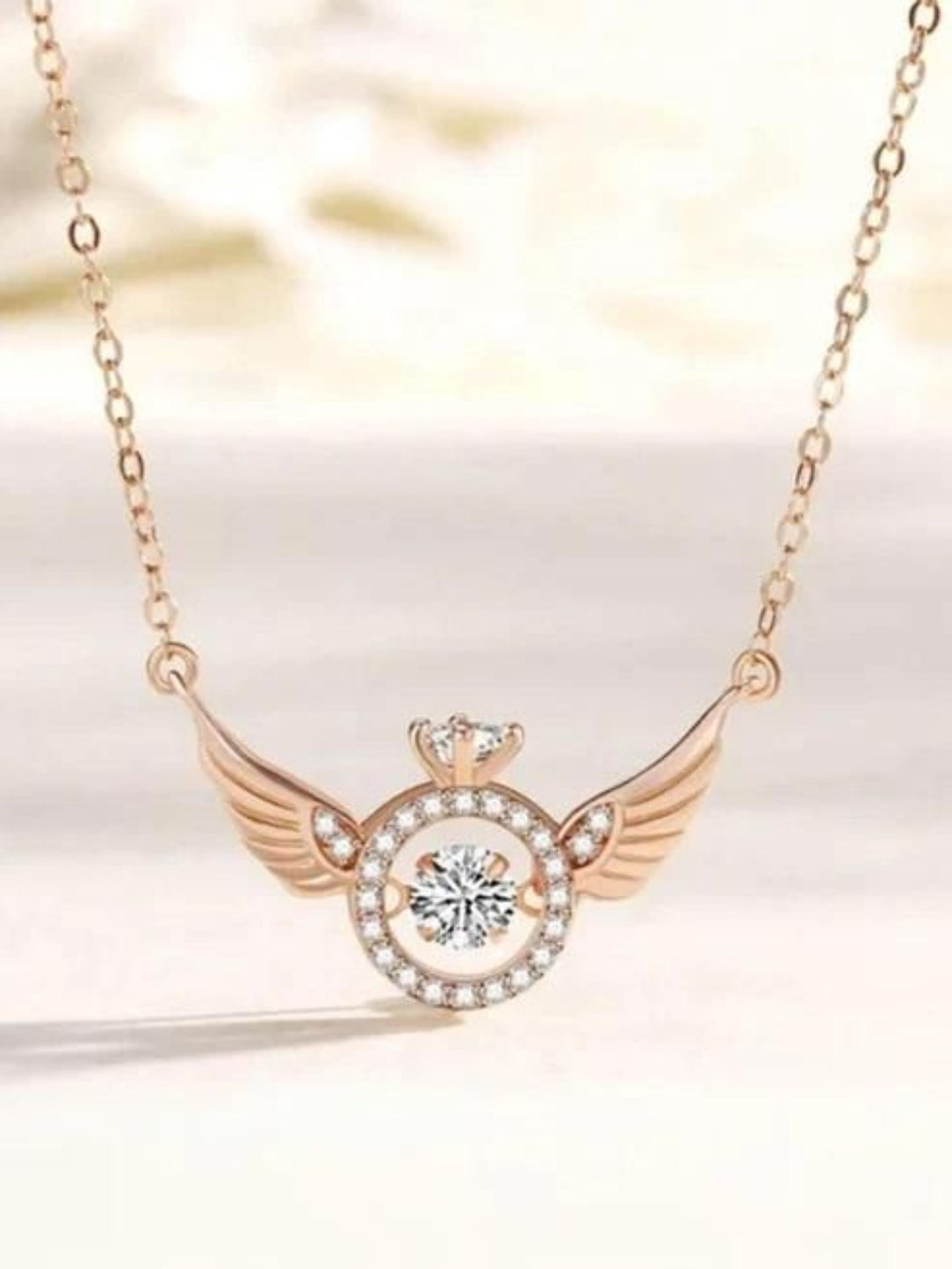 Necklace with a heart and wings design on a soft background