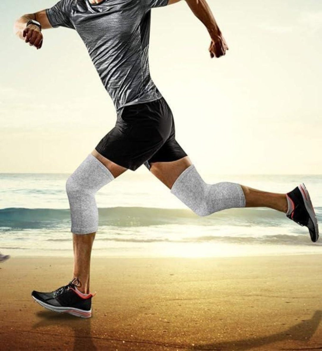 Person running on a beach wearing gray compression socks