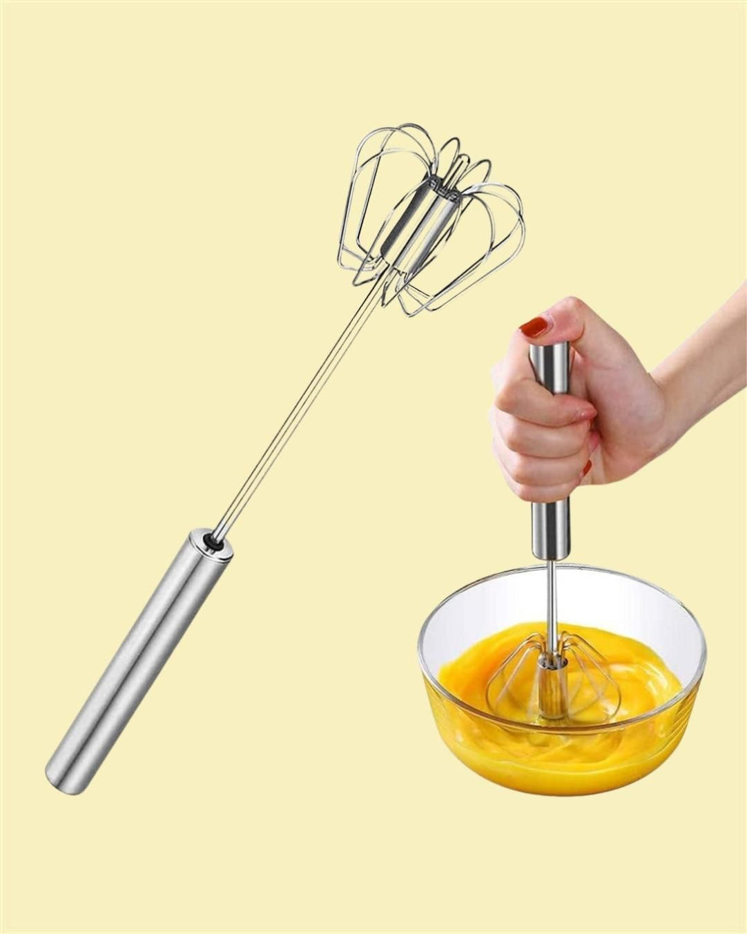 A hand is using a manual stainless steel kitchen hand whisk mixer over a bowl of egg yolks on a kitchen counter.