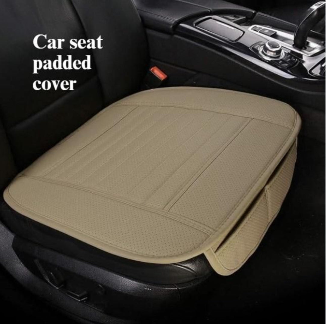 A beige car seat bottom cover placed on a seat in a vehicle interior.