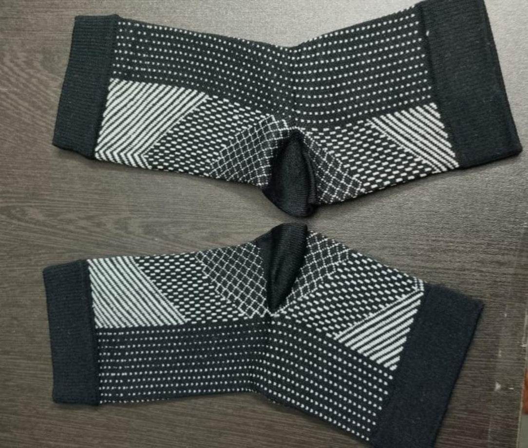 Pair of black and white patterned knee sleeves on a wooden surface