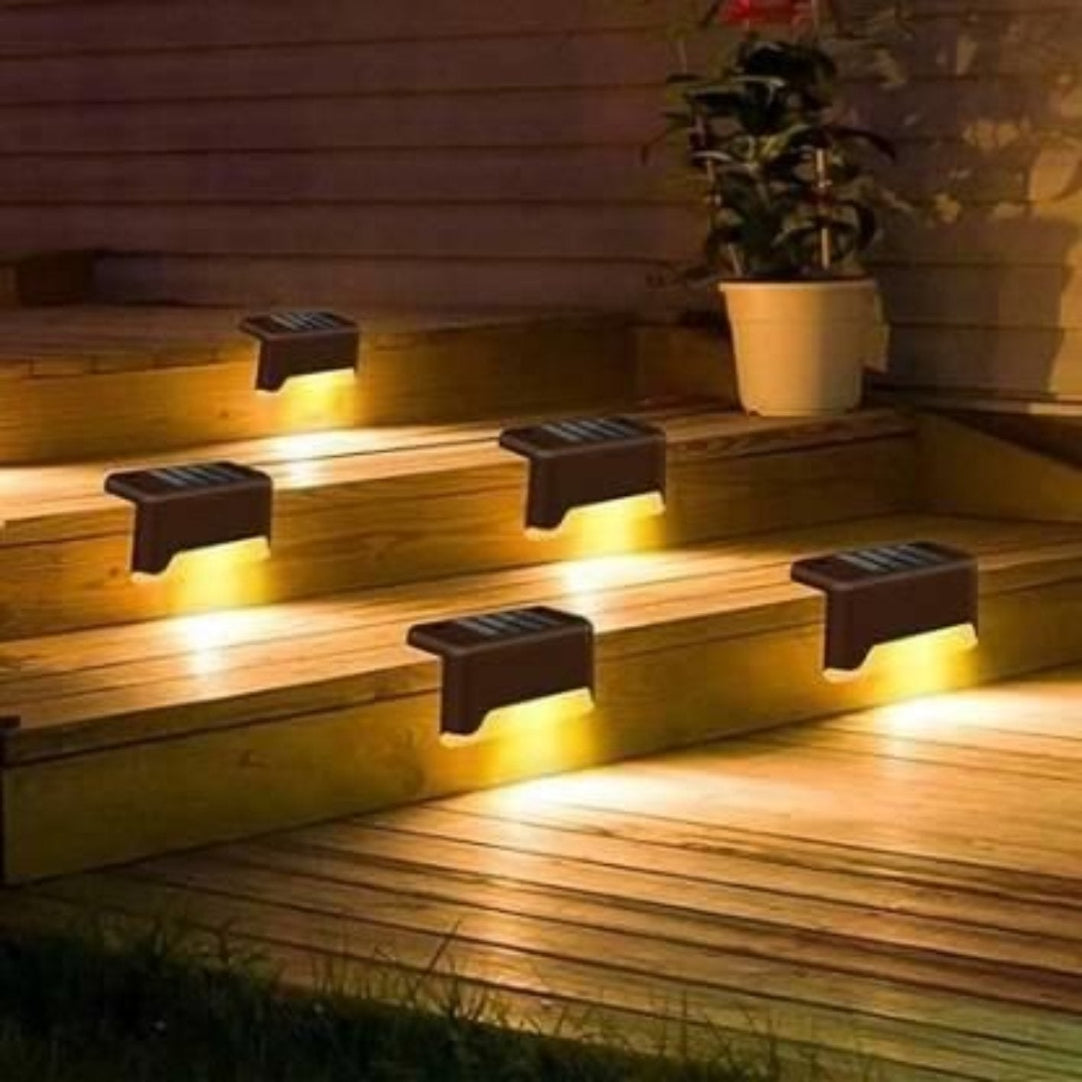 Solar-powered LED deck lights installed on outdoor wooden steps, providing a warm yellow glow.