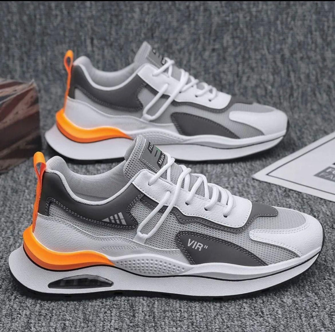 Gray, black, and orange sneakers on a textured surface