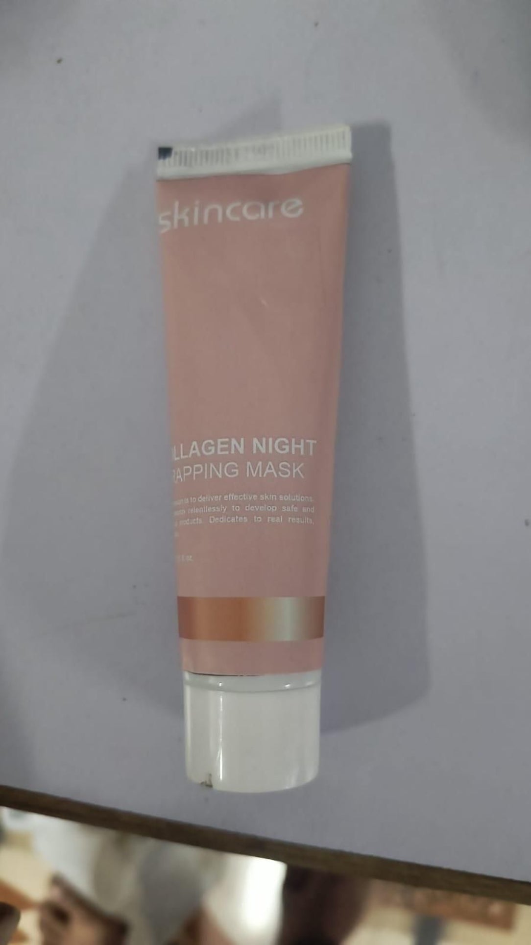 Skincare collagen night topping mask tube on a light gray background