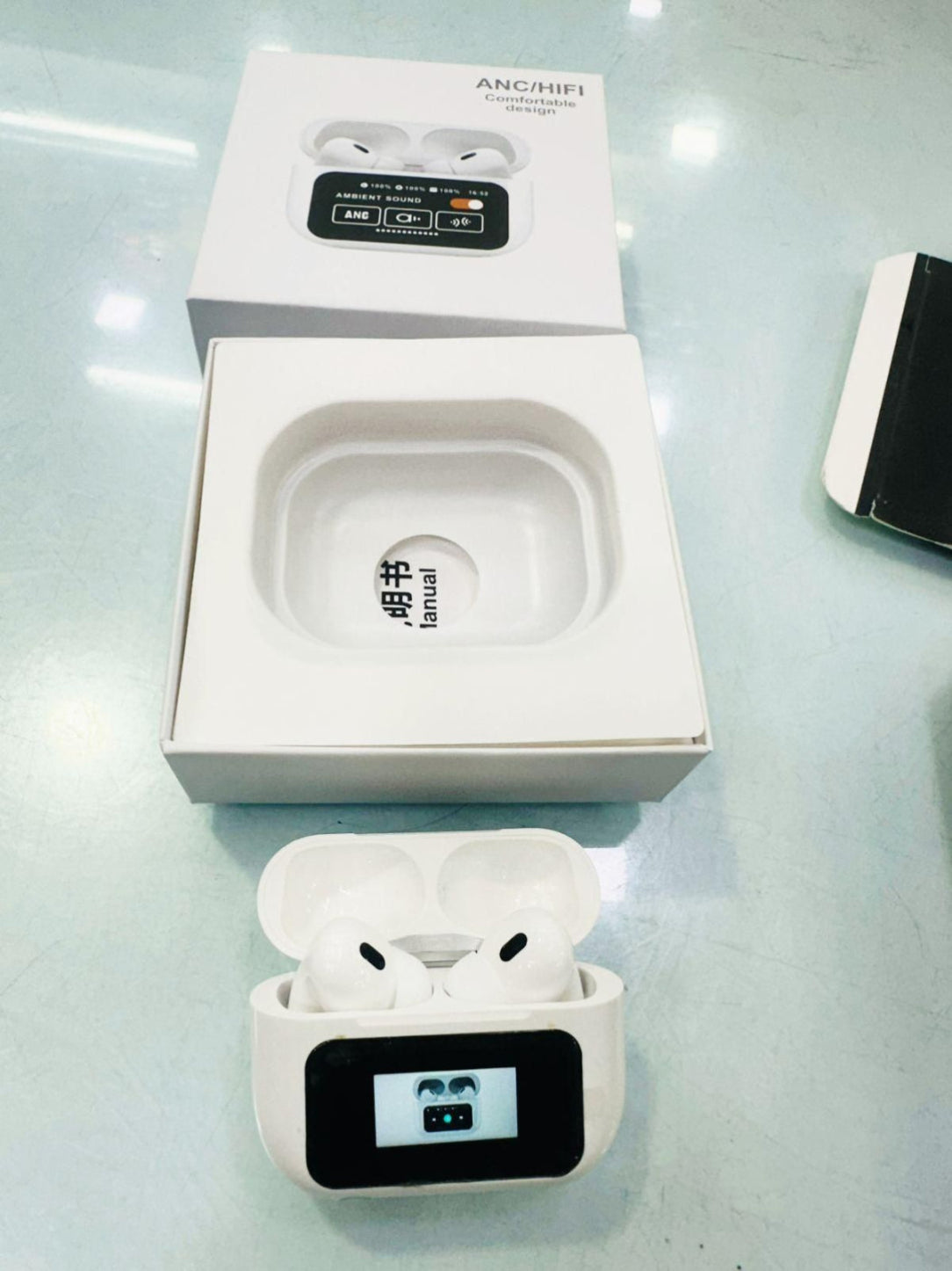 Wireless earbuds with charging case on a reflective surface