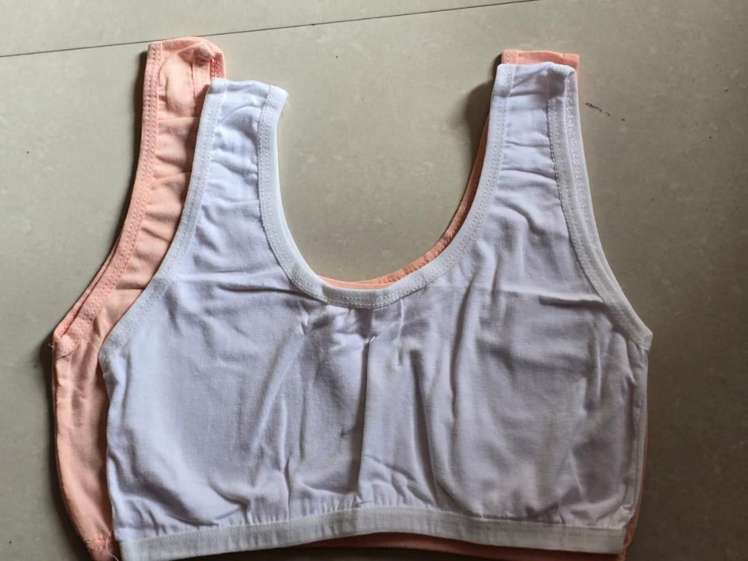 Light gray sports bra with pink trim on a gray background