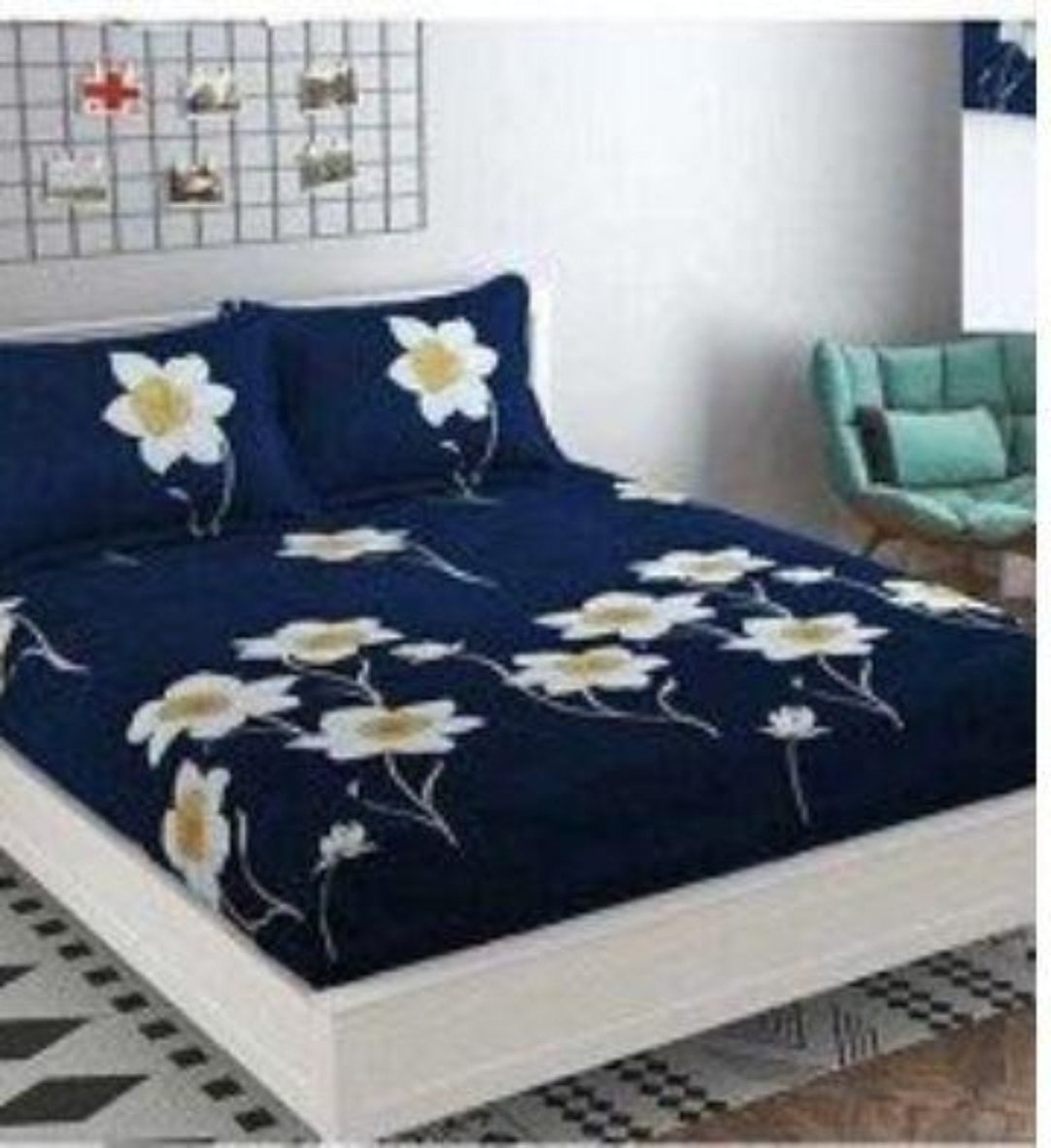 A double bedsheet set with floral pattern on a navy blue background, displayed on a bed with two pillowcases, in a room with decorative items on the walls.