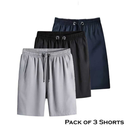 A pack of three men's shorts in different colors, showcasing a pair of gray shorts, a pair of black shorts, and a pair of navy blue shorts, all with elastic waistbands.
