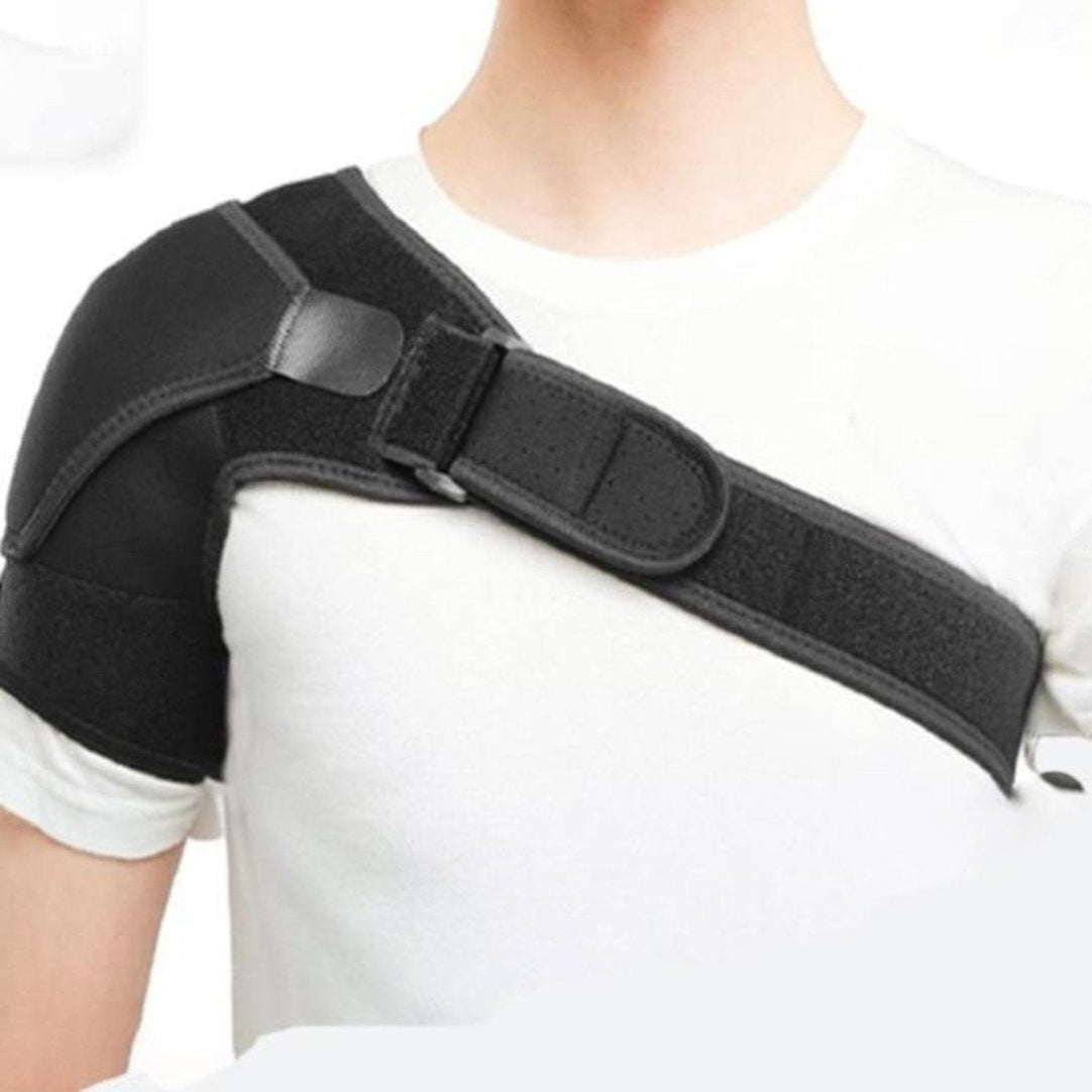 A person wearing a black adjustable shoulder support back brace with straps around the shoulders and back.
