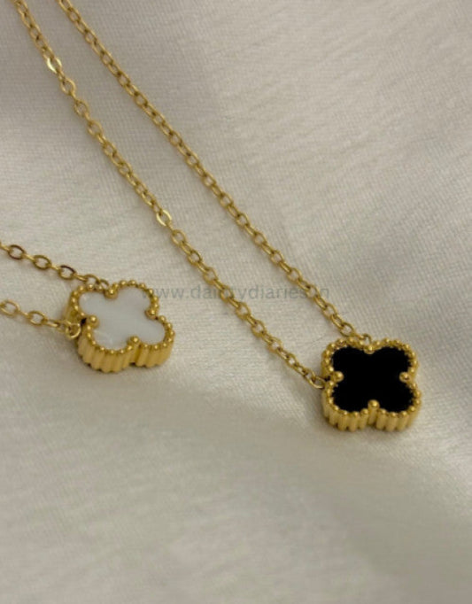 A gold-colored double side chain necklace laid out on a white surface.