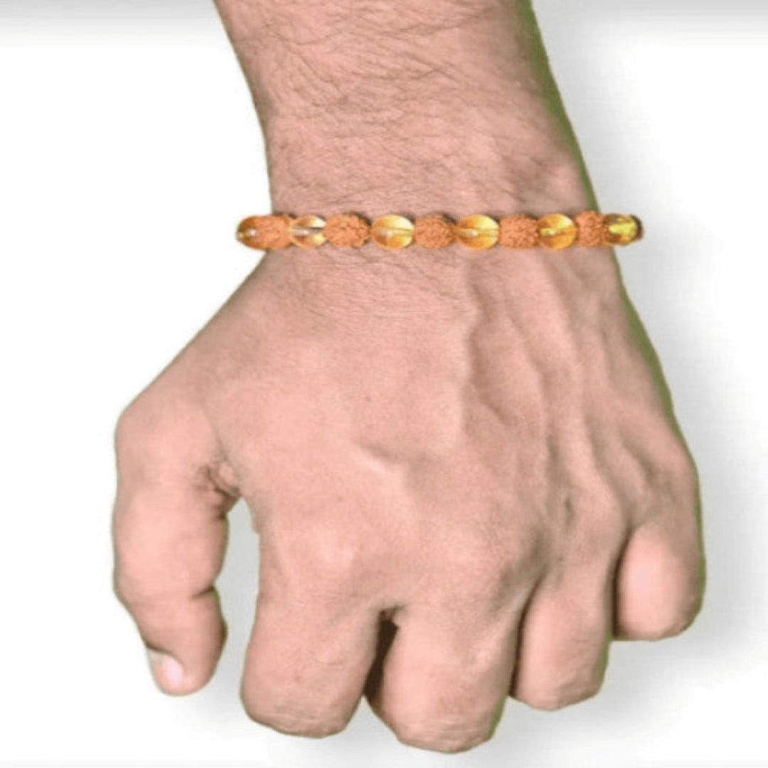 Gold bracelet on a wrist against a white background